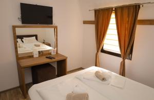 a bedroom with a bed and a mirror and a television at Planinska Kraljica in Gornje Pale