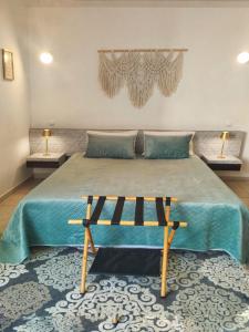 a bedroom with a large bed with a bench on it at Golden Refúgio das Andorinhas in Cabanas de Tavira +32 photos