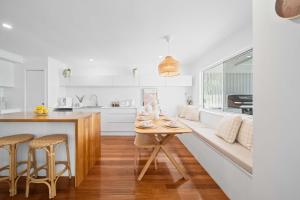 a kitchen with a table and chairs and a couch at Palm Cove Retreat - Walk to beach & CBD in Maroochydore
