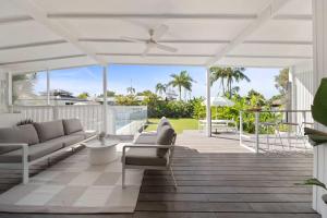 a living room with a couch and a ceiling fan at Palm Cove Retreat - Walk to beach & CBD in Maroochydore
