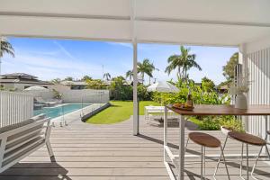 a patio with a table and chairs and a pool at Palm Cove Retreat - Walk to beach & CBD in Maroochydore +50 photos
