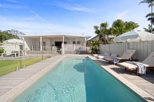 a swimming pool in the backyard of a house at Palm Cove Retreat - Walk to beach & CBD in Maroochydore