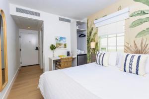 a bedroom with a white bed and a desk at Casa Ocean in Miami Beach