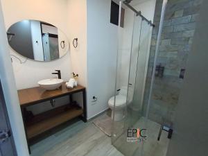 a bathroom with a sink and a shower with a mirror at Epic Suite 312 Deluxe Airport in Cuba