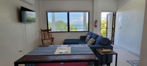 a living room with a blue couch and a table at Lickety Split Unit 3, Northside Ocean View in Caye Caulker