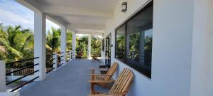 a balcony of a house with two chairs at Lickety Split Unit 3, Northside Ocean View in Caye Caulker +12 photos