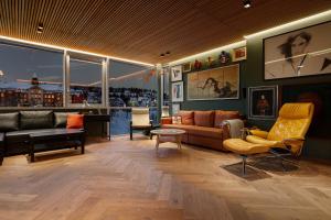 un soggiorno con divano e sedie di The Gallery Penthouse by Paramount a Tromsø