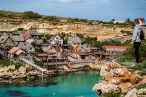 un uomo in piedi su una collina che guarda un fiume di Modern, stylish & comfortable 3 bedroom apartment with jacuzzi, aquarium and private yard with barbeque a Mellieħa