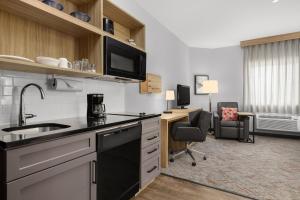 una cucina con un lavandino e una scrivania in una stanza di Candlewood Suites - Texas City by IHG a Texas City