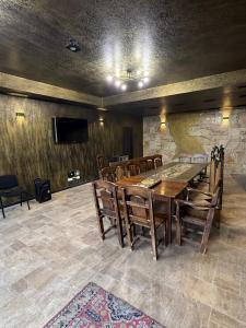 una sala da pranzo con tavolo, sedie e TV di LusakertHouse a Nor Gyugh