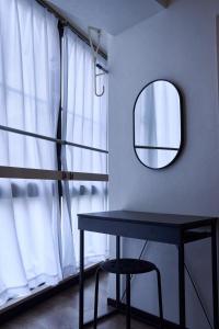 een tafel in een kamer met een spiegel en een raam bij New Open! Central Kobe 最大9名 三宮,元町,中華街,北野へアクセス抜群 長期宿泊設備充実 in Kobe +42 foto's