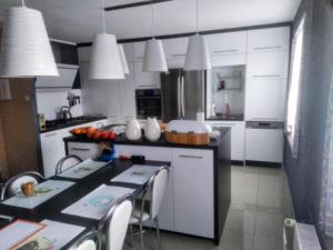 a kitchen with white cabinets and a table with chairs at Słoneczna Przystań in Wrocław