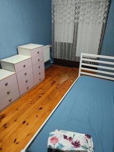 a bedroom with a blue bed and a dresser at Słoneczna Przystań in Wrocław