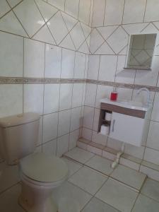 Un baño blanco con inodoro y lavabo. en Kitnet Praia do Porto, en Imbituba 23 fotos más