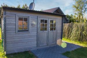 a small wooden shed with a door in a yard at Ferienhaus Aurora in Twist