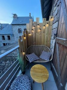 a balcony with a chair and a table and a fence at Gite du Lac Pavin in Besse-et-Saint-Anastaise