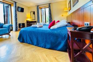 a bedroom with a blue bed with pillows on it at Hotel Punta me Torreblanca Palace in Guadarrama