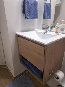 ein Badezimmer mit weißem Waschbecken und blauen Handtüchern in der Unterkunft Céntrico y preciso en Coquimbo in Coquimbo