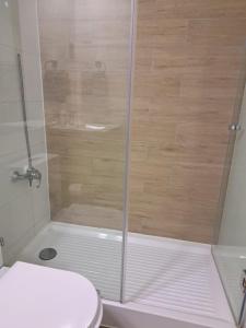 eine Dusche mit Glastür neben einer Toilette in der Unterkunft Céntrico y preciso en Coquimbo in Coquimbo