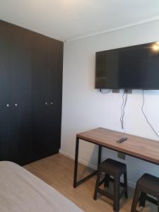 Schlafzimmer mit einem Schreibtisch und einem TV an der Wand in der Unterkunft Céntrico y preciso en Coquimbo in Coquimbo