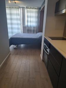 ein kleines Zimmer mit einem Bett in einer Küche in der Unterkunft Céntrico y preciso en Coquimbo in Coquimbo