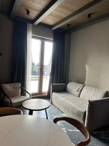 ein Wohnzimmer mit Sofa und Tisch in der Unterkunft Apartman Stotka in Kopaonik