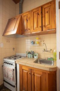 cocina con armarios de madera, fregadero y fogones en HOSTEL COLIVING STUDIO JUNIN, en Junín 5 fotos más