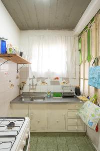 Una pequeña cocina con fregadero y estufa. en HOSTEL COLIVING STUDIO JUNIN, en Junín