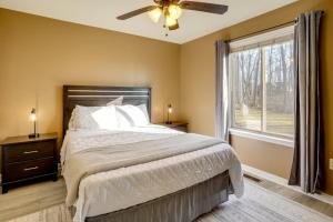 Schlafzimmer mit einem Bett, einem Deckenventilator und einem Fenster in der Unterkunft Winter Linden Escape Family Home and Gym in Front Royal