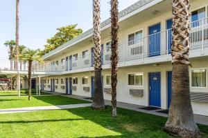 ein Gebäude mit Palmen davor in der Unterkunft Motel 6-Bakersfield, CA - East in Bakersfield