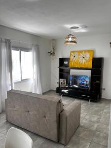 ein Wohnzimmer mit Sofa und Flachbildfernseher in der Unterkunft Departamento con patio y garaje y parrilla in San Fernando del Valle de Catamarca