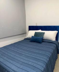 Luxury في كالي: سرير ازرق وابيض في الغرفة