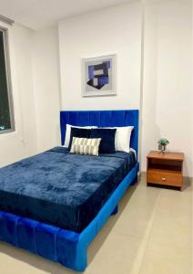 Luxury في كالي: سرير أزرق في غرفة مع موقف ليلي