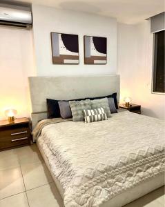 Luxury في كالي: غرفة نوم بها سرير كبير وطاولتين جانبيتين