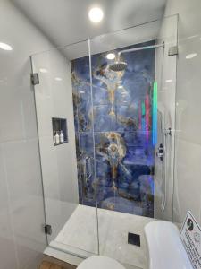 a bathroom with a shower with a painting on the wall at Close to hard rock stadium and guitar casino in Pembroke Pines
