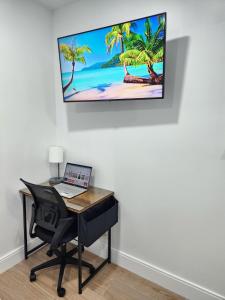 a desk with a laptop and a computer on a wall at Close to hard rock stadium and guitar casino in Pembroke Pines +61 photos