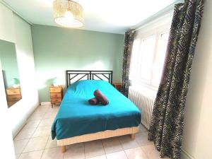 a bedroom with a blue bed and a window at charmant T2 avec jardin et parking in Agen