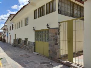 库斯科Centro Cusco Inti的街道上带绿门的白色建筑