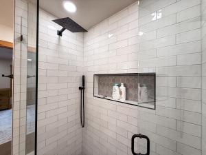 a bathroom with a shower with white tiled walls at Lakefront Beauty in Rocky Point +64 photos
