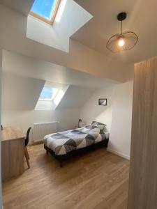 ein Schlafzimmer mit einem Bett und einem Dachfenster in der Unterkunft la maison des copains, garage et wifi in Amiens + 20 Fotos