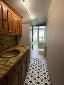 ein Bad mit 2 Waschbecken und Fliesenboden in der Unterkunft la maison des copains, garage et wifi in Amiens