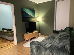 a living room with a couch and a flat screen tv at Tromsø Central Stay in Tromsø