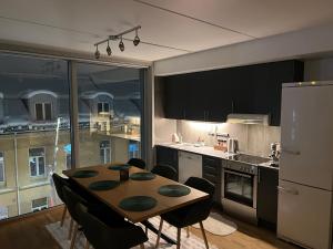 a kitchen with a table and chairs and a refrigerator at Tromsø Central Stay in Tromsø