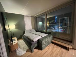a bedroom with a bed and a large window at Tromsø Central Stay in Tromsø