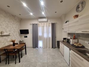 a kitchen with a table and a counter top at Casa vacanze al teatro in Catania
