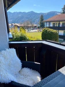 a balcony with a seat with a view of a yard at Apartmenthaus Der Johanneshof - tolle Lage nah am See in Schliersee