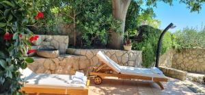 ein Liegestuhl und ein Bett auf einer Terrasse in der Unterkunft Villa Rapkinja in Rab