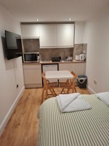 a small kitchen with a table and a table and chairs at The Greenwood Guest Room in Brimsdown Station