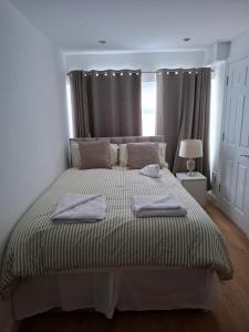 a bedroom with a bed with two towels on it at The Greenwood Guest Room in Brimsdown Station