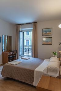 ミラノにあるホテル デル ソルの大きなベッドとバルコニーのある寝室